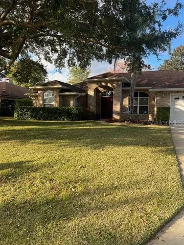 a front view of a house with a garden and lake view