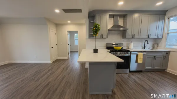 a kitchen with a sink a cabinets and wooden floor