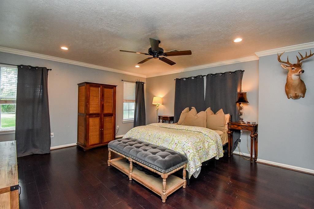 29400 Waller Gladish Road Waller, TX 77484 - Photo 14 of 39 a bedroom with a bed and a chandelier