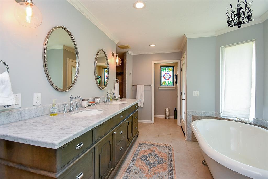 29400 Waller Gladish Road Waller, TX 77484 - Photo 16 of 39 a bathroom with a granite countertop tub a double vanity sink and a large mirror