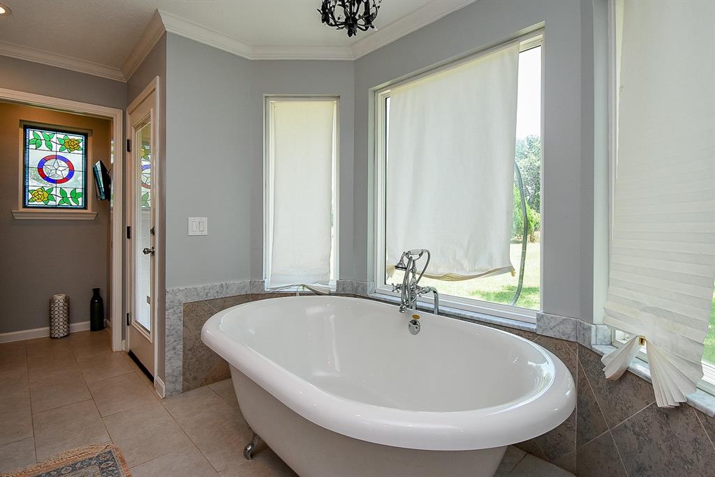 29400 Waller Gladish Road Waller, TX 77484 - Photo 17 of 39 a white bath tub sitting in a bathroom next to a window