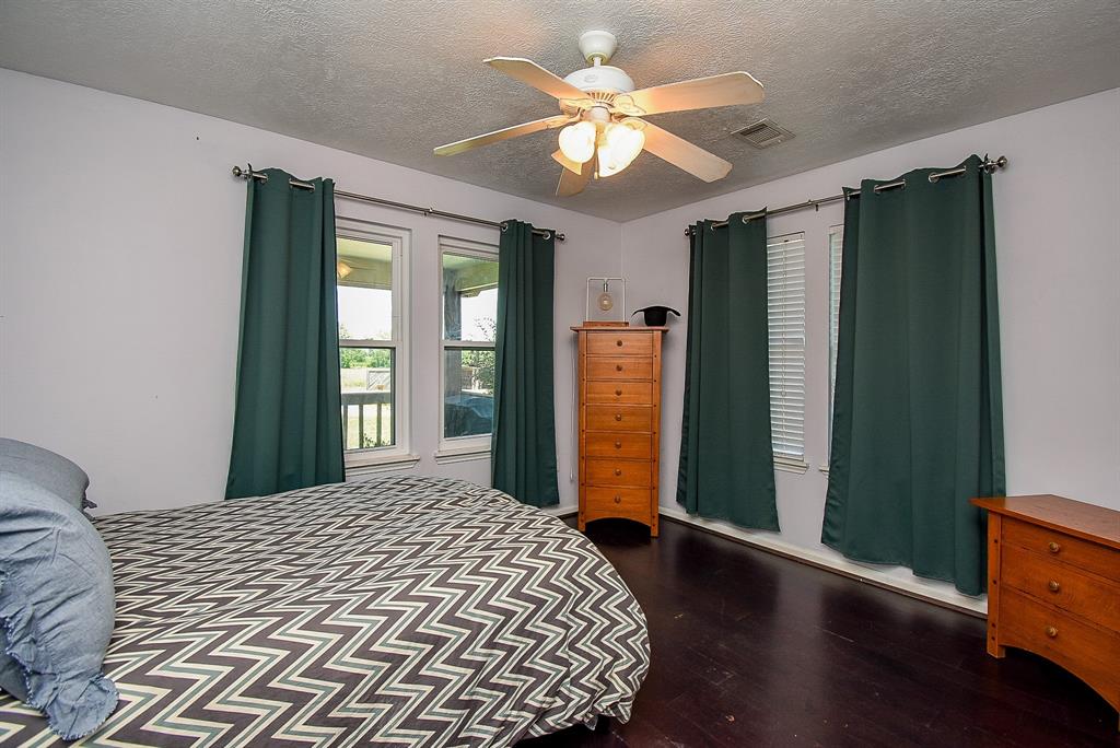 29400 Waller Gladish Road Waller, TX 77484 - Photo 25 of 39 a bedroom with a large bed and a chandelier