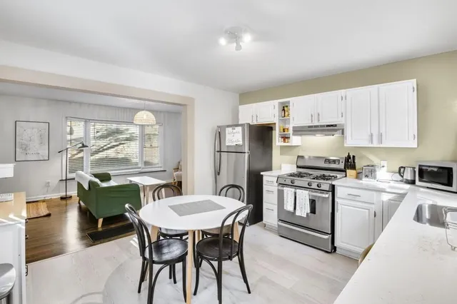 a kitchen with a table chairs stove and refrigerator