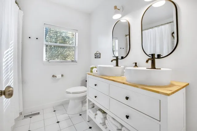 a bathroom with a granite countertop toilet a sink and a mirror