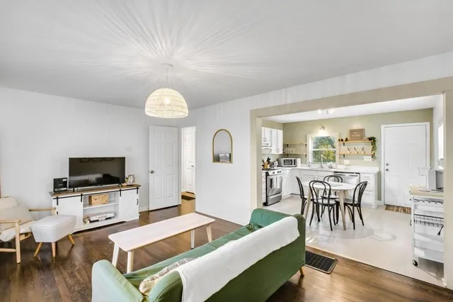 a living room with furniture a dining table and a flat screen tv