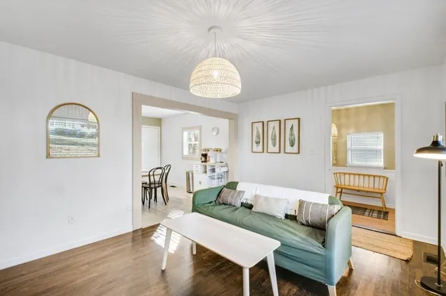 a living room with furniture a table and wooden floor