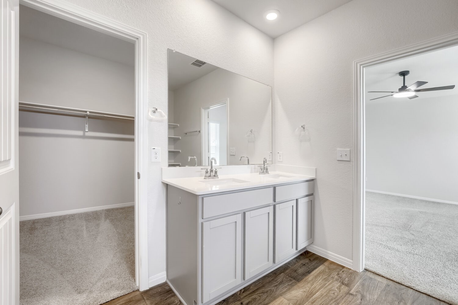 13507 Howser Trace Manor, TX 78653 - Photo 13 of 28 Double vanity with ample storage and wood flooring provides a functional, neutral space.