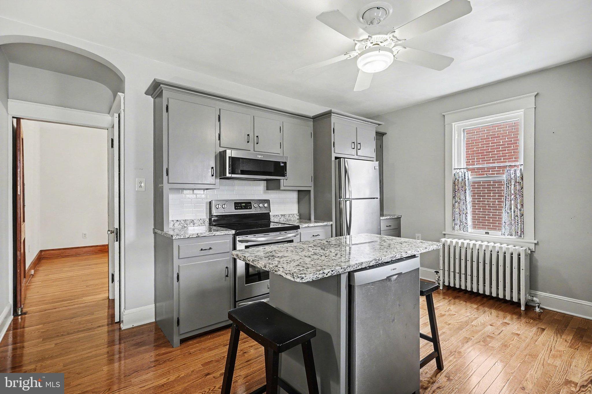 144 Seminary Avenue Gettysburg, PA 17325 - Photo 11 of 28 a kitchen with stainless steel appliances granite countertop a refrigerator a stove a sink dishwasher a dining table and chairs with wooden floor