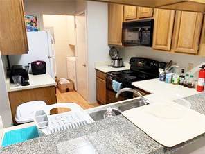 806 West 24th Street, Unit 229 Austin, TX 78705 - Photo 11 of 23 a kitchen with a sink stove and refrigerator