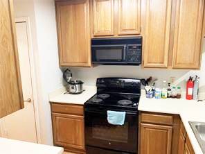 806 West 24th Street, Unit 229 Austin, TX 78705 - Photo 8 of 23 a kitchen with a stove and a microwave