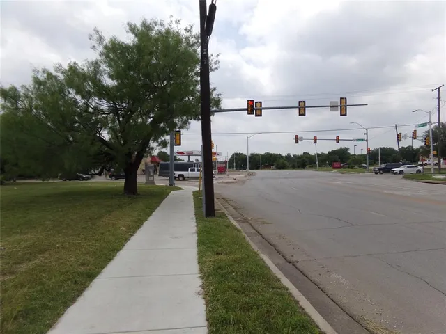 a view of street with houses and trees in the background