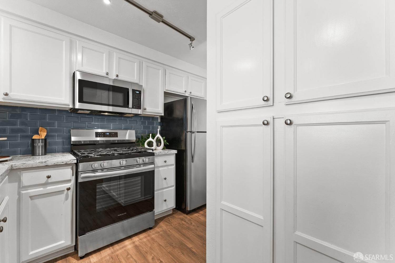 280 Caldecott Lane, Unit 101 Oakland, CA 94618 - Photo 5 of 32 a kitchen with stainless steel appliances white cabinets white stove a refrigerator and a microwave