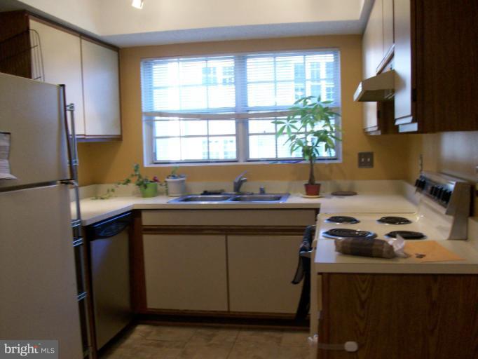 115 Fort Evans Road Southeast, Unit C Leesburg, VA 20175 - Photo 7 of 10 a kitchen with a sink cabinets and window