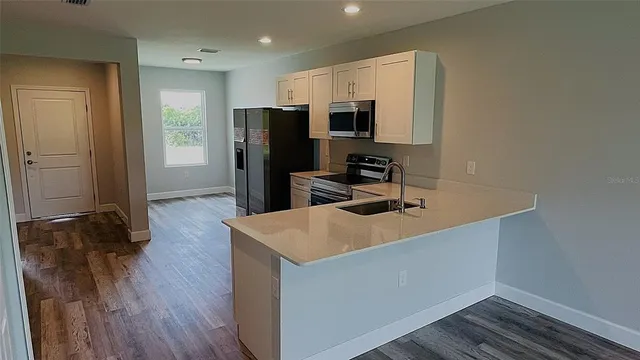 a view of a small space with wooden floor and a sink