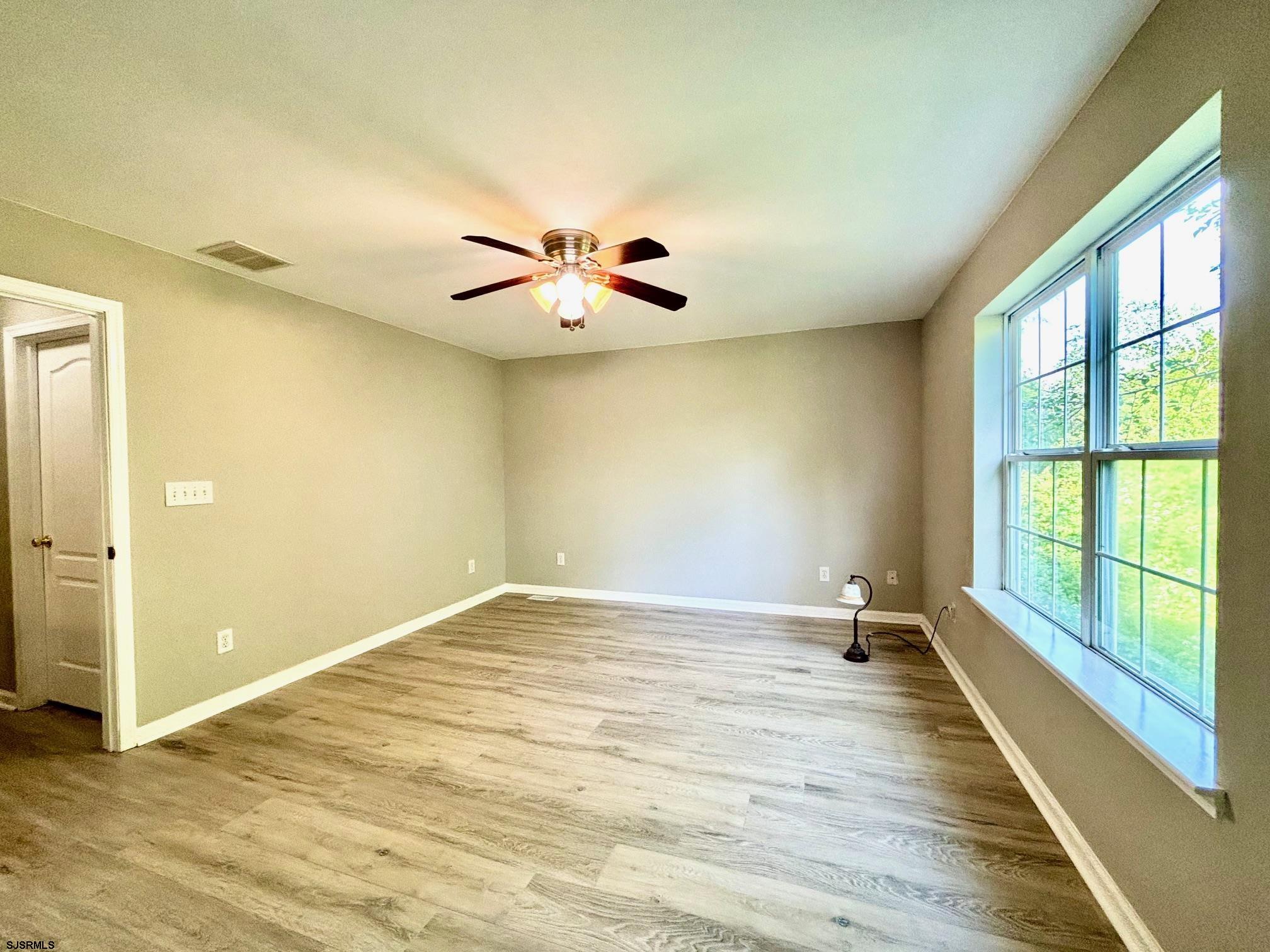 27 Oyster Bay, Unit G Absecon, NJ 08201 - Photo 20 of 31 wooden floor in an empty room with a window