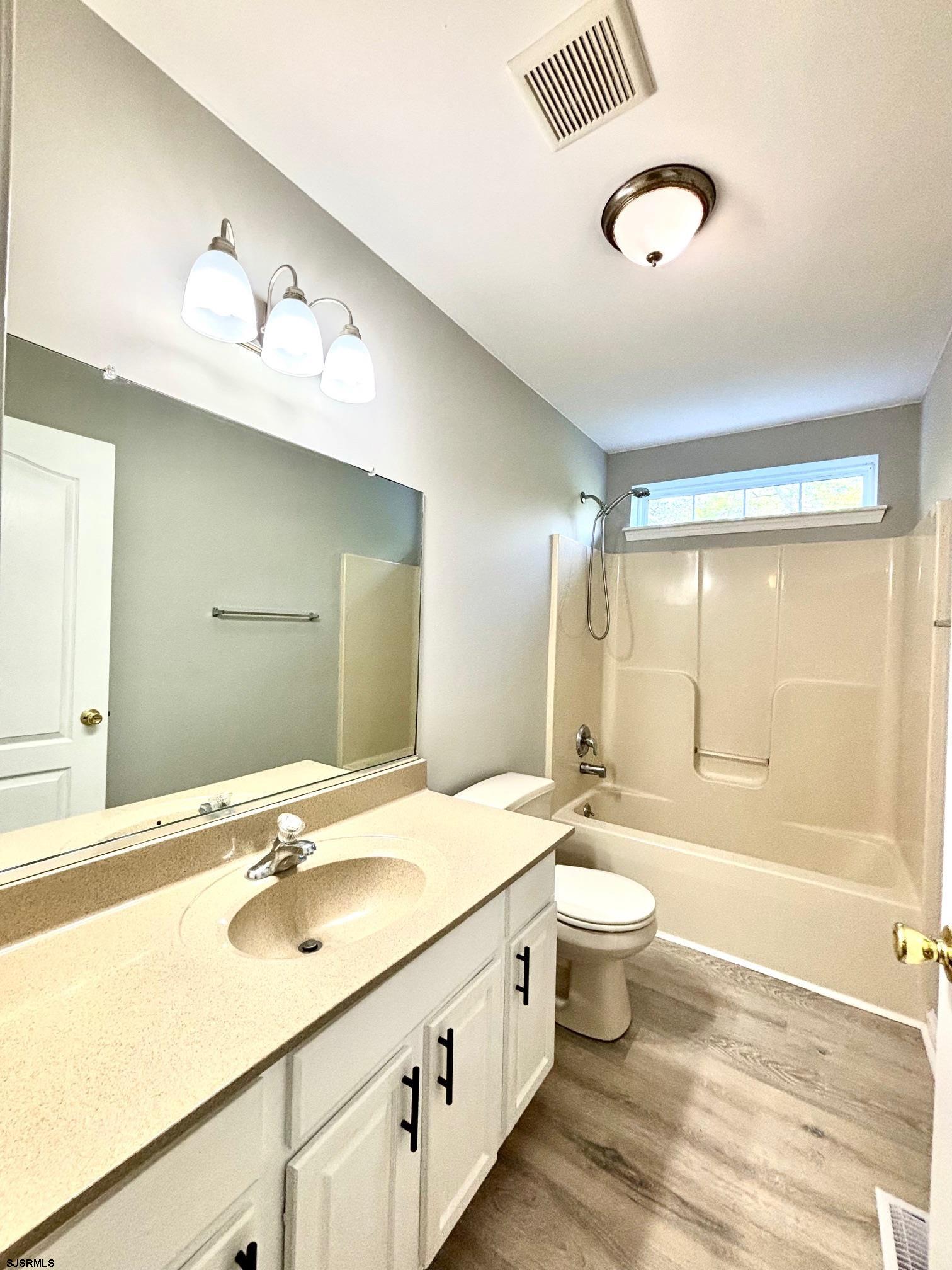 27 Oyster Bay, Unit G Absecon, NJ 08201 - Photo 21 of 31 a bathroom with a double vanity sink toilet and a mirror