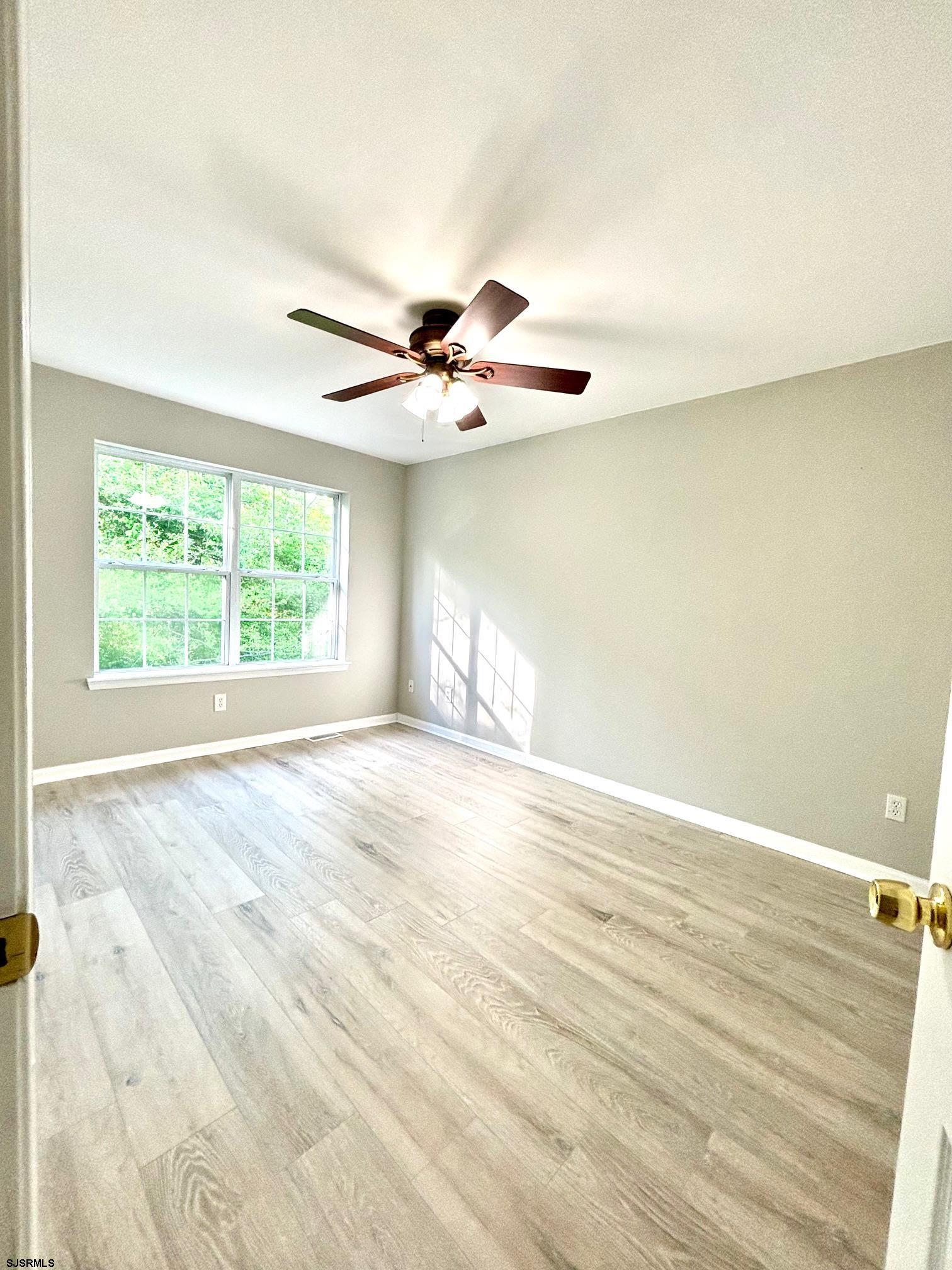 27 Oyster Bay, Unit G Absecon, NJ 08201 - Photo 24 of 31 an empty room with wooden floor and windows