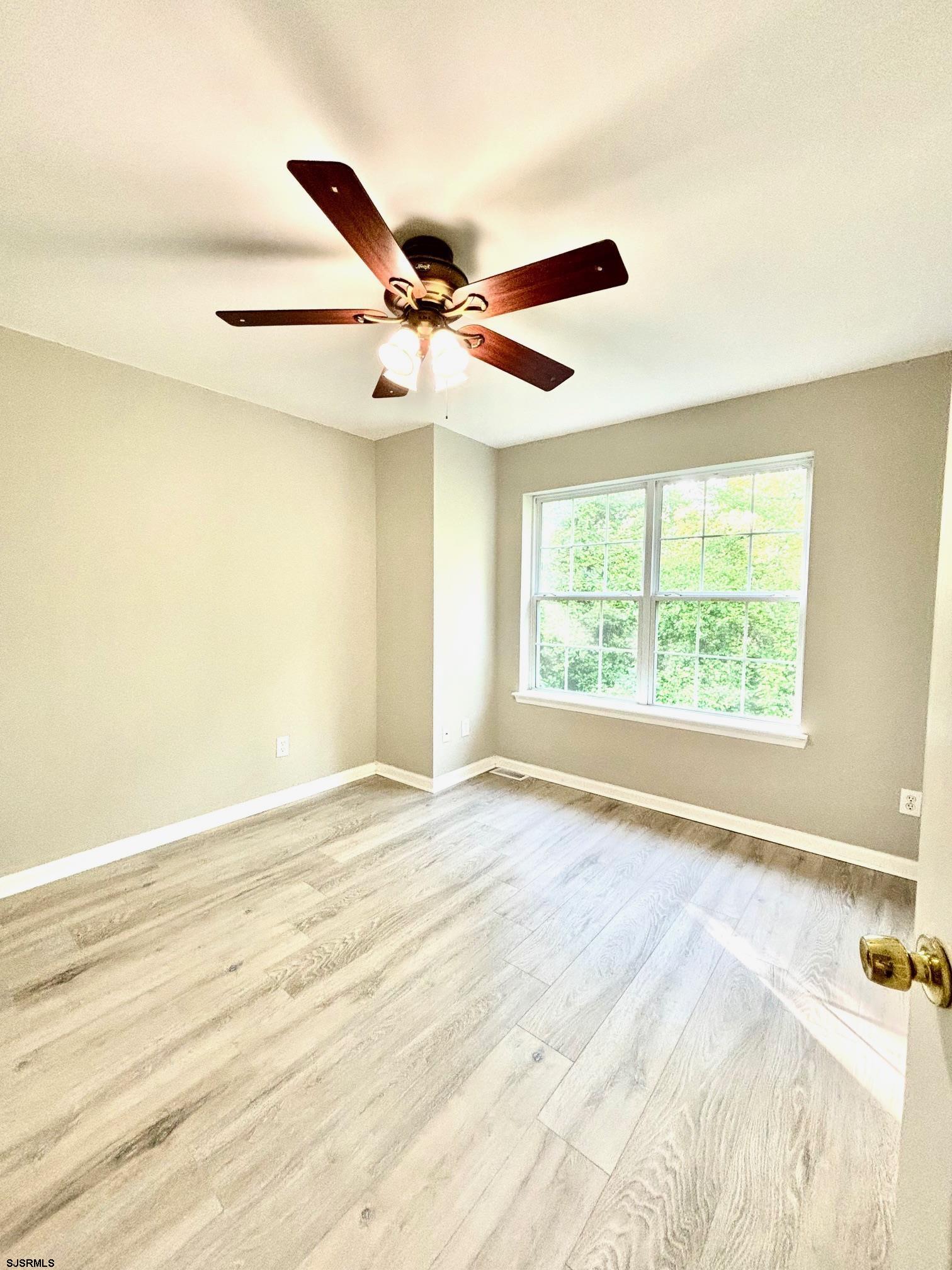 27 Oyster Bay, Unit G Absecon, NJ 08201 - Photo 25 of 31 a view of an empty room with window and a ceiling fan