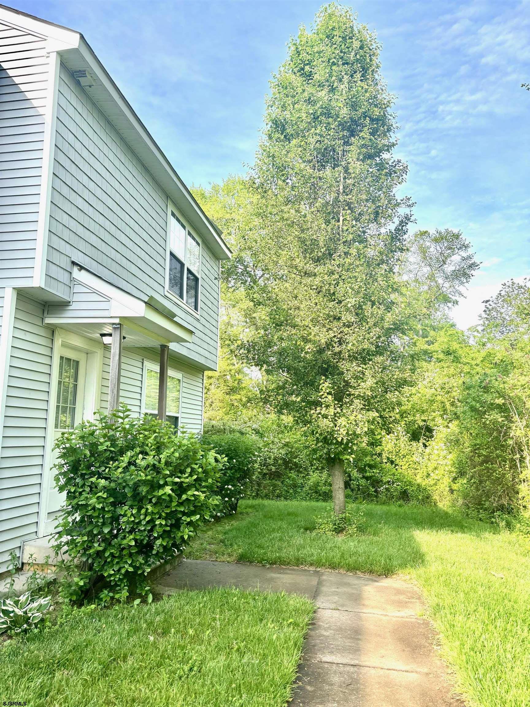 27 Oyster Bay, Unit G Absecon, NJ 08201 - Photo 3 of 31 a front view of a house with a garden