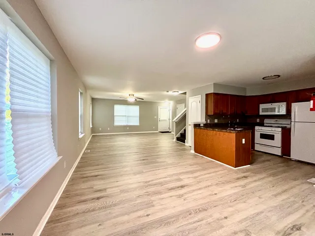 a view of kitchen with kitchen island sink and wooden floor