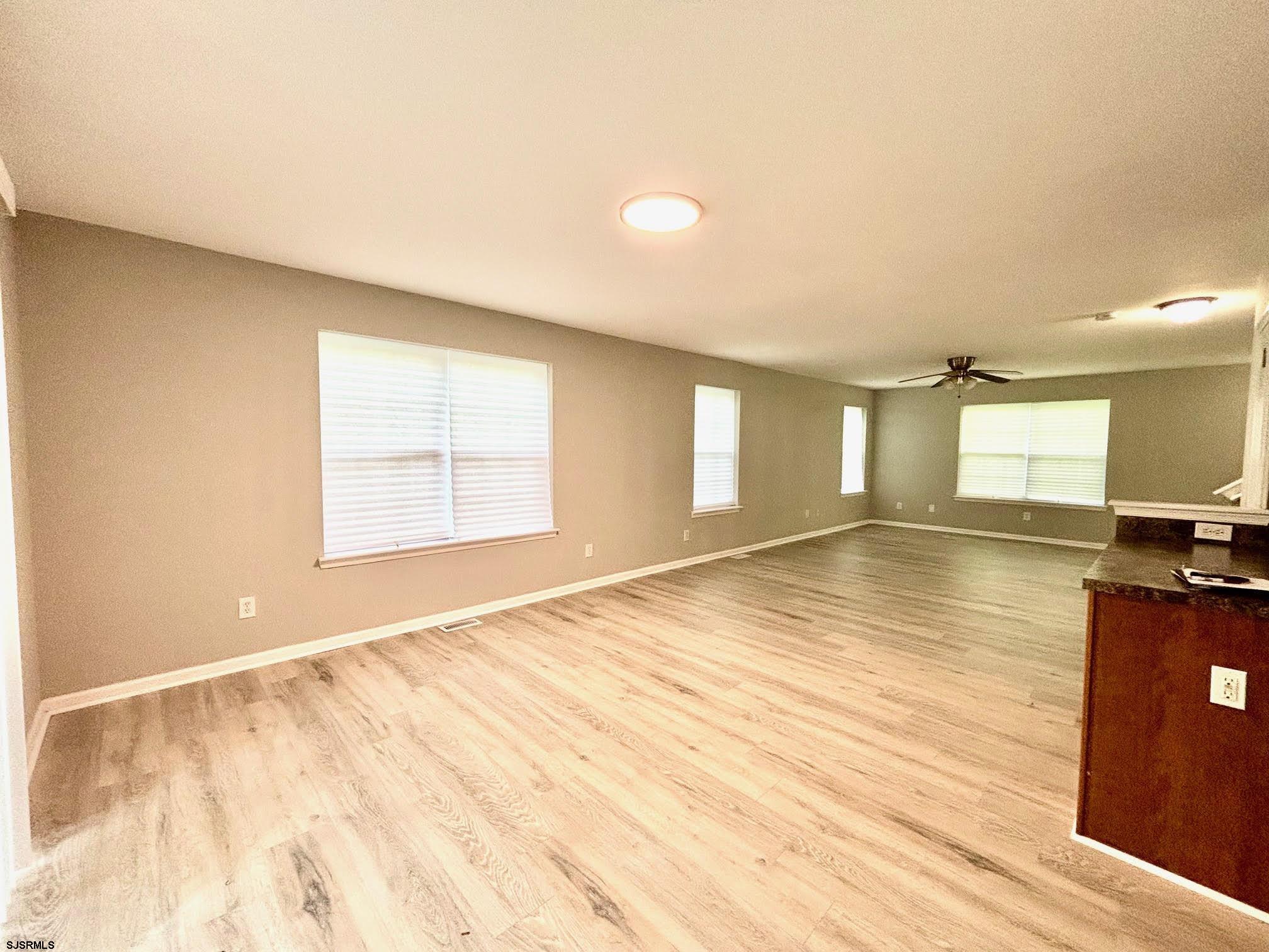 27 Oyster Bay, Unit G Absecon, NJ 08201 - Photo 10 of 31 a view of an empty room with window and wooden floor