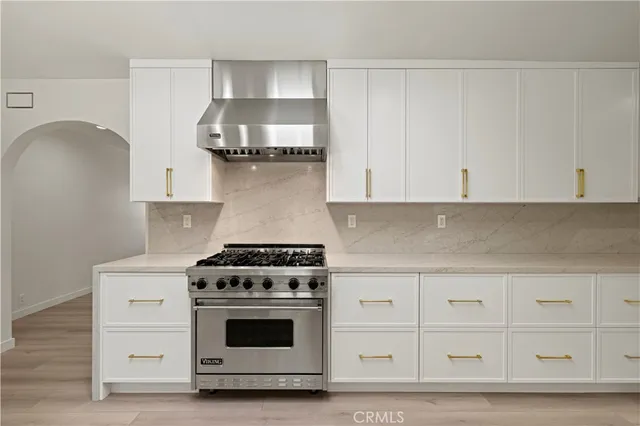 a kitchen with stainless steel appliances a sink cabinets and wooden floor