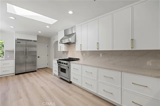 a large kitchen with stainless steel appliances granite countertop a large counter top and a wooden floors