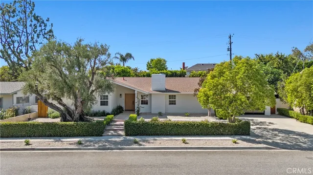 an aerial view of a house with a yard and a large tree