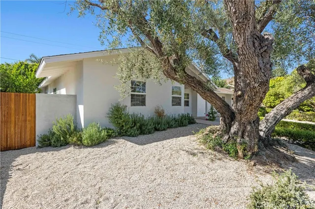 a view of a backyard with table and chairs under an umbrella