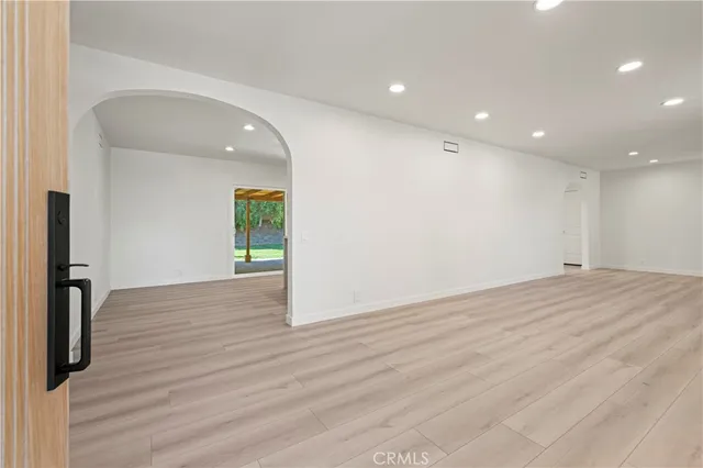 a view of empty room with wooden floor and fireplace