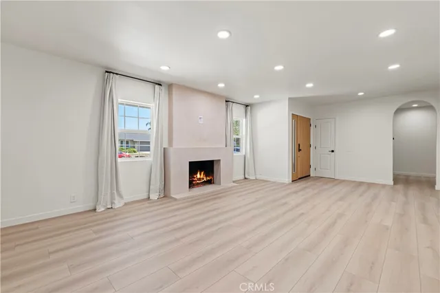a view of empty room with wooden floor and window