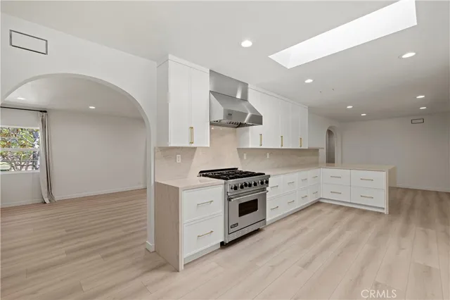 a kitchen with stainless steel appliances a sink stove and cabinets