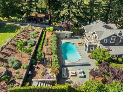 an aerial view of residential house with outdoor space and trees all around