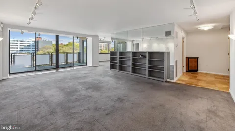 a view of an empty room with furniture and a window