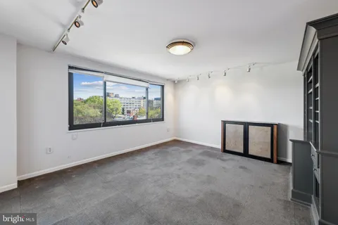 a view of empty room with furniture and window