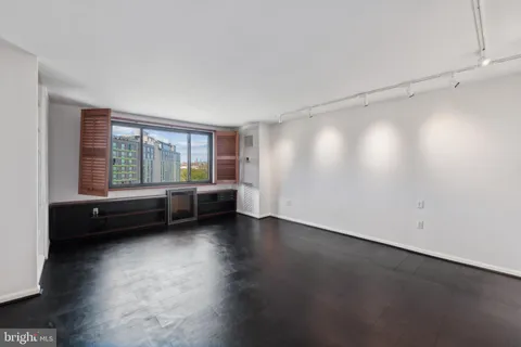 a view of a room with wooden floor and windows