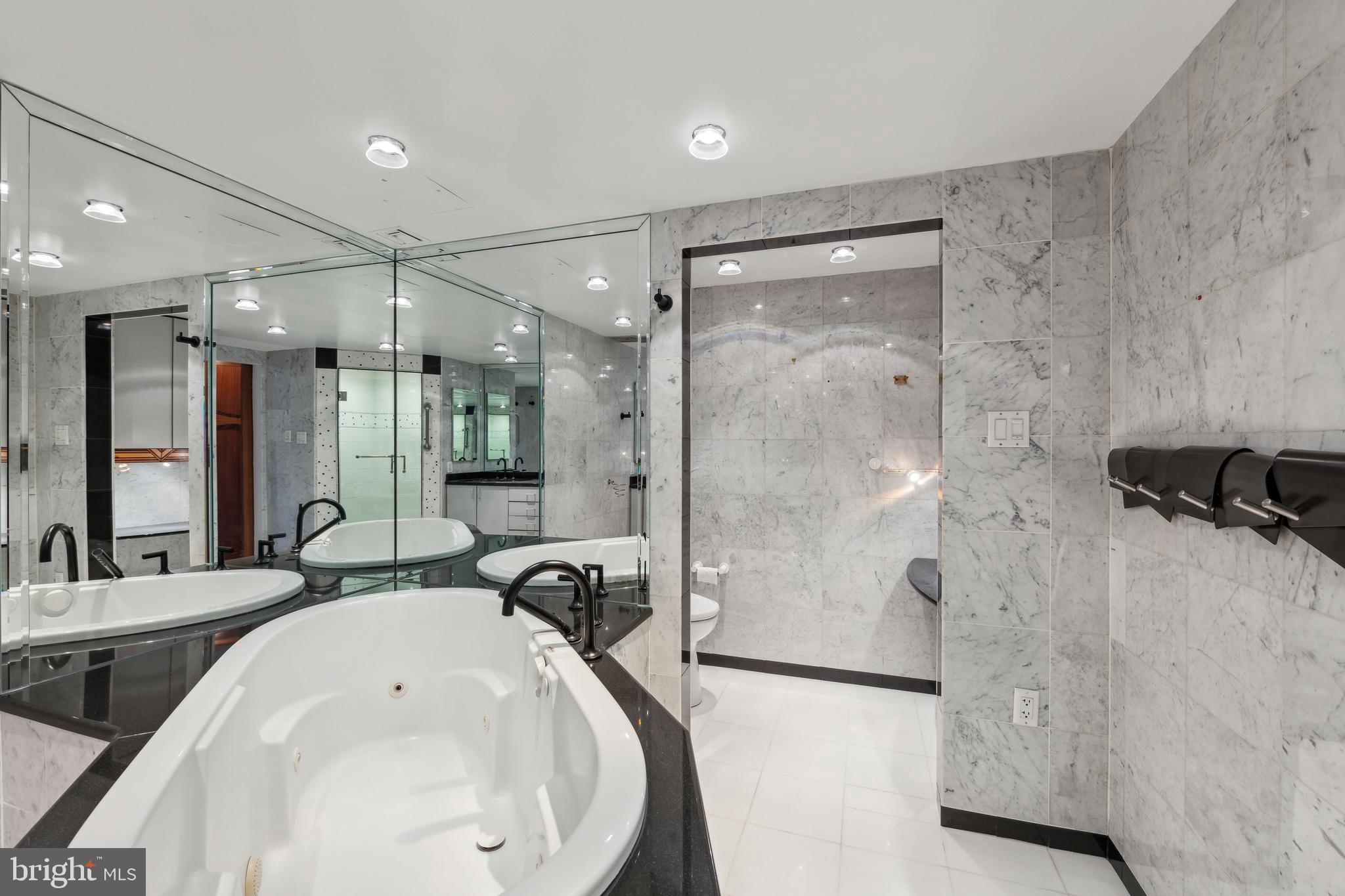 800 25th Street Northwest, Unit 605 Washington, DC 20037 - Photo 26 of 35 a large bathroom with a tub shower sink and mirror