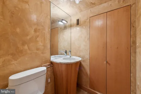 a bathroom with a granite countertop sink toilet and a mirror