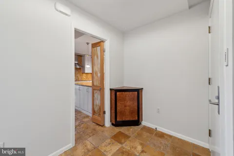 a view of an empty room with closet and wooden floor