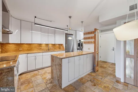 a kitchen with stainless steel appliances granite countertop a sink and a refrigerator