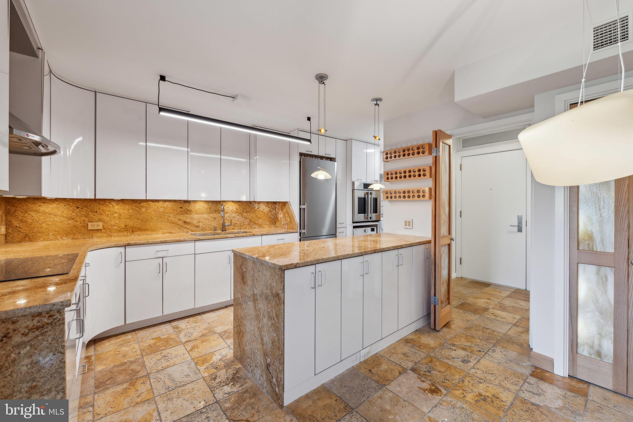 800 25th Street Northwest, Unit 605 Washington, DC 20037 - Photo 10 of 35 a kitchen with kitchen island granite countertop wooden cabinets and white appliances