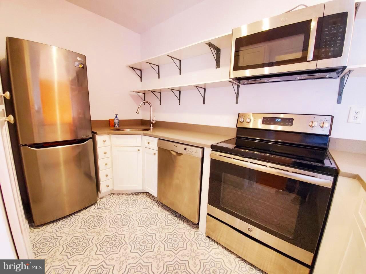4301 Massachusetts Avenue Northwest, Unit 6007 Washington, DC 20016 - Photo 8 of 24 a kitchen with stainless steel appliances a stove microwave and a refrigerator