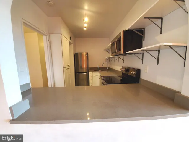 a kitchen with stainless steel appliances kitchen island wooden floor