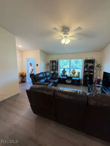 a living room with furniture a chandelier and a flat screen tv