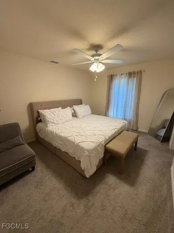 a bedroom with bed couch and window