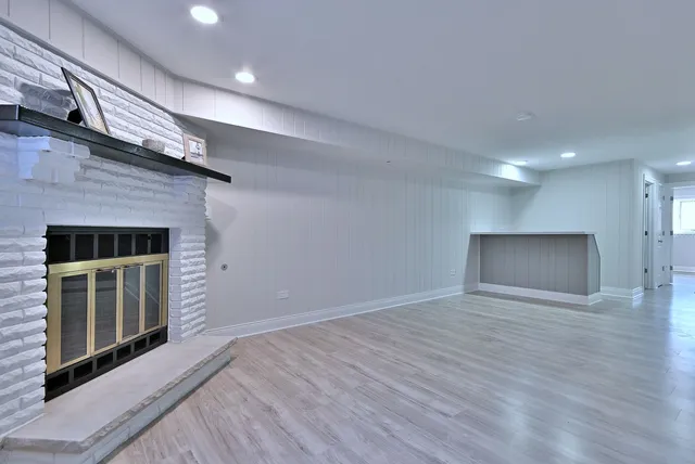 an empty room with wooden floor and fireplace