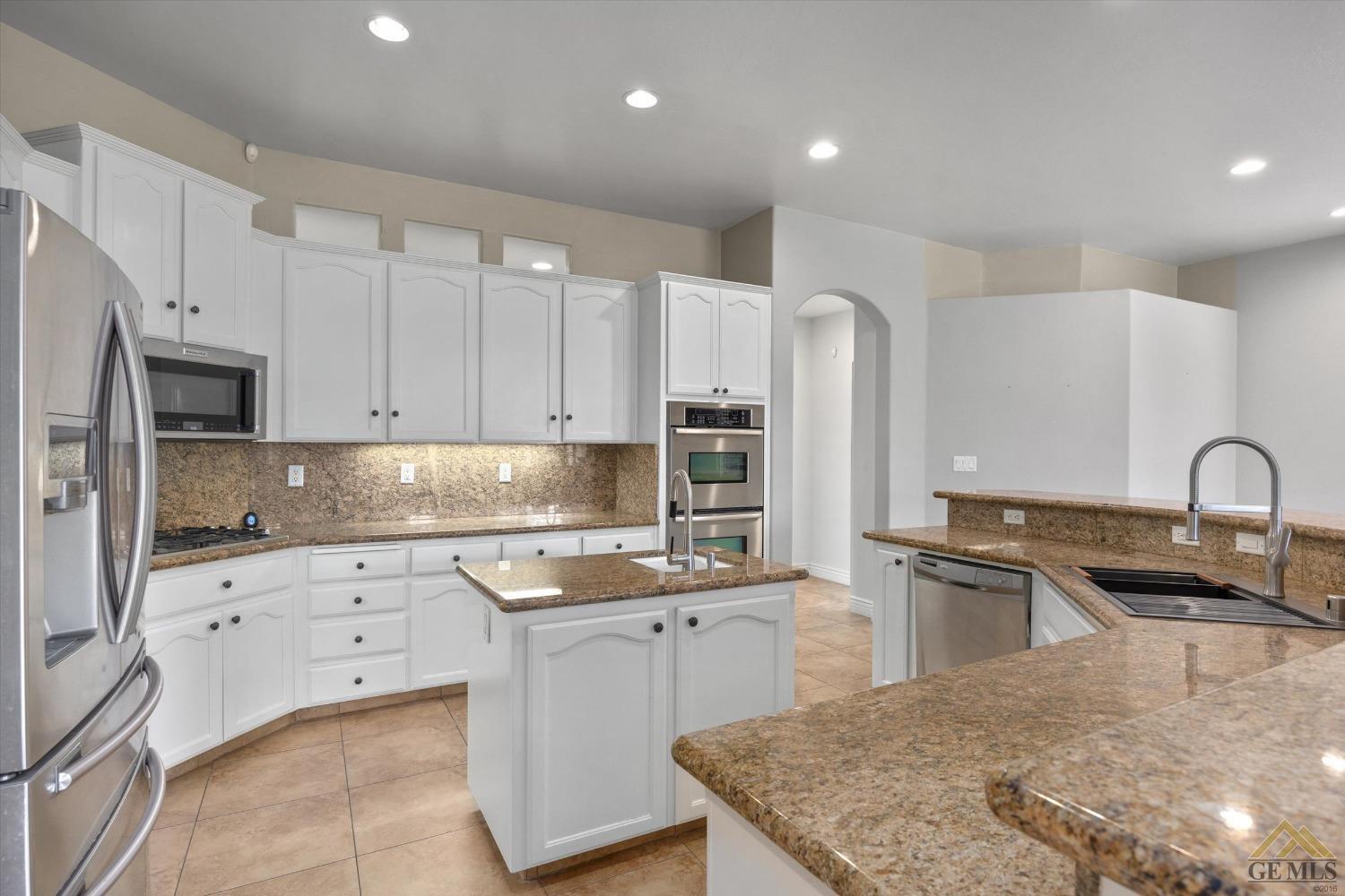 Undisclosed Address Bakersfield, CA 93311 - Photo 27 of 57 a kitchen with granite countertop a sink stove and refrigerator