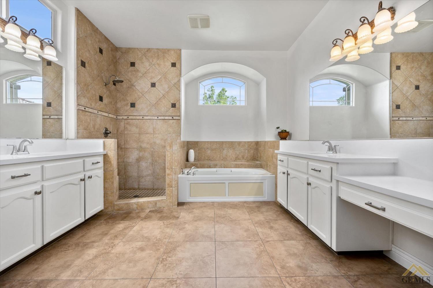 Undisclosed Address Bakersfield, CA 93311 - Photo 38 of 57 a spacious bathroom with a double vanity sink a mirror a bathtub and a window
