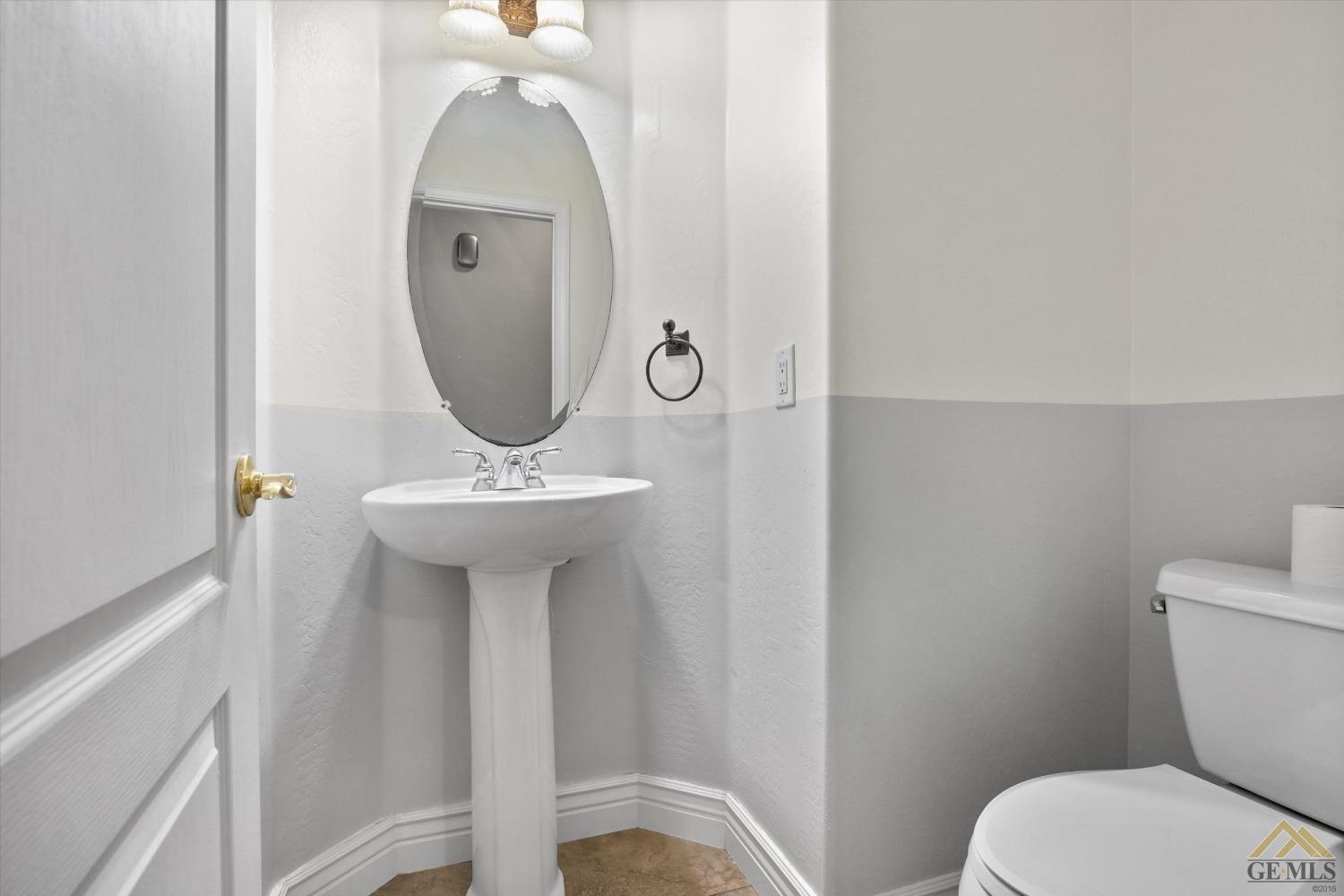 Undisclosed Address Bakersfield, CA 93311 - Photo 49 of 57 a bathroom with a toilet a sink and a mirror