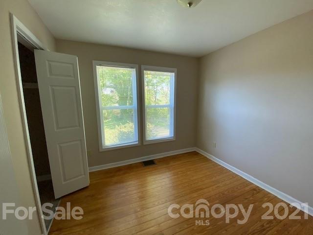 369 North Canton Road Canton, NC 28716 - Photo 11 of 21 an empty room with wooden floor and windows
